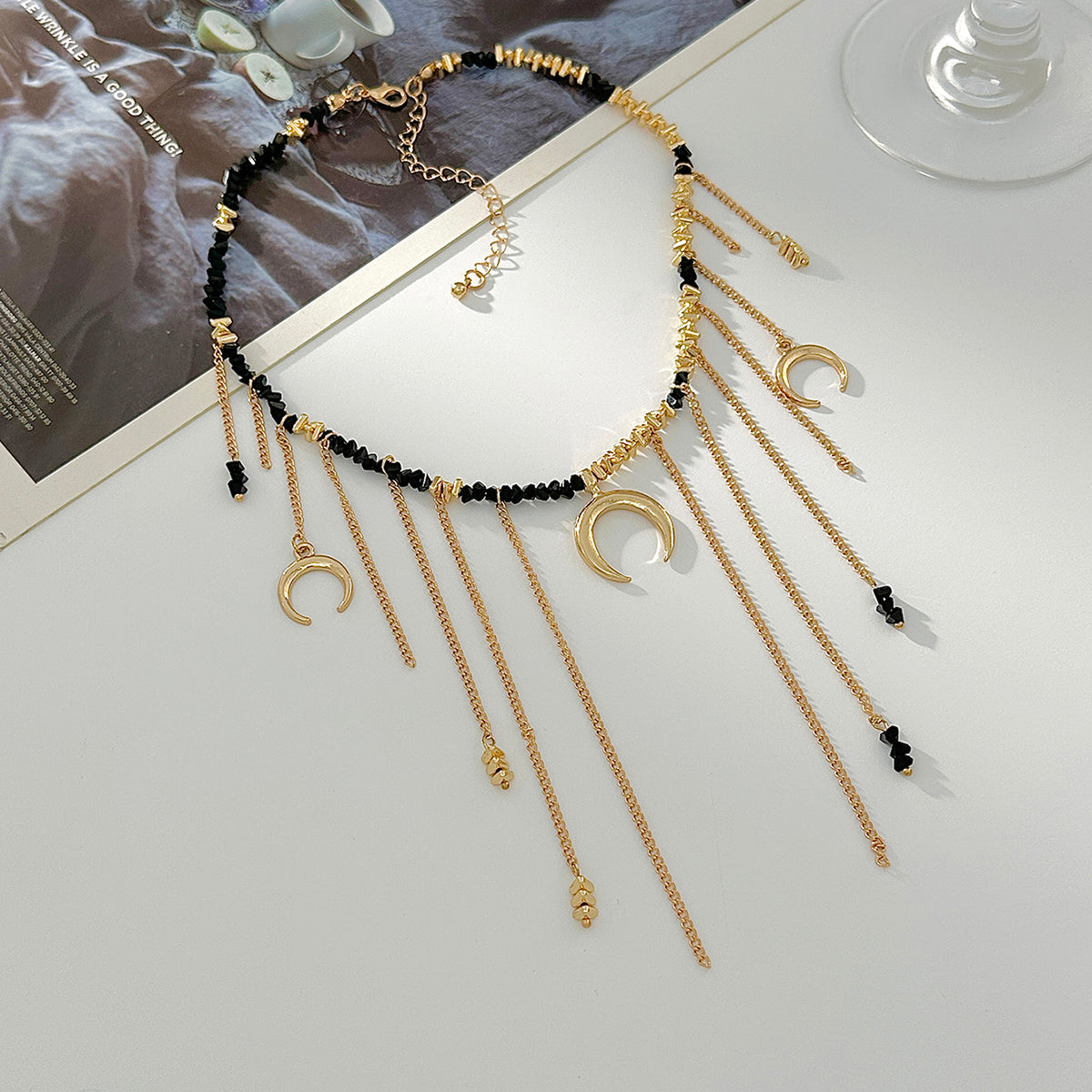 Black Acrylic and Goldtone Moon Pendant Tassel Necklace, dainty minimalist design, side view