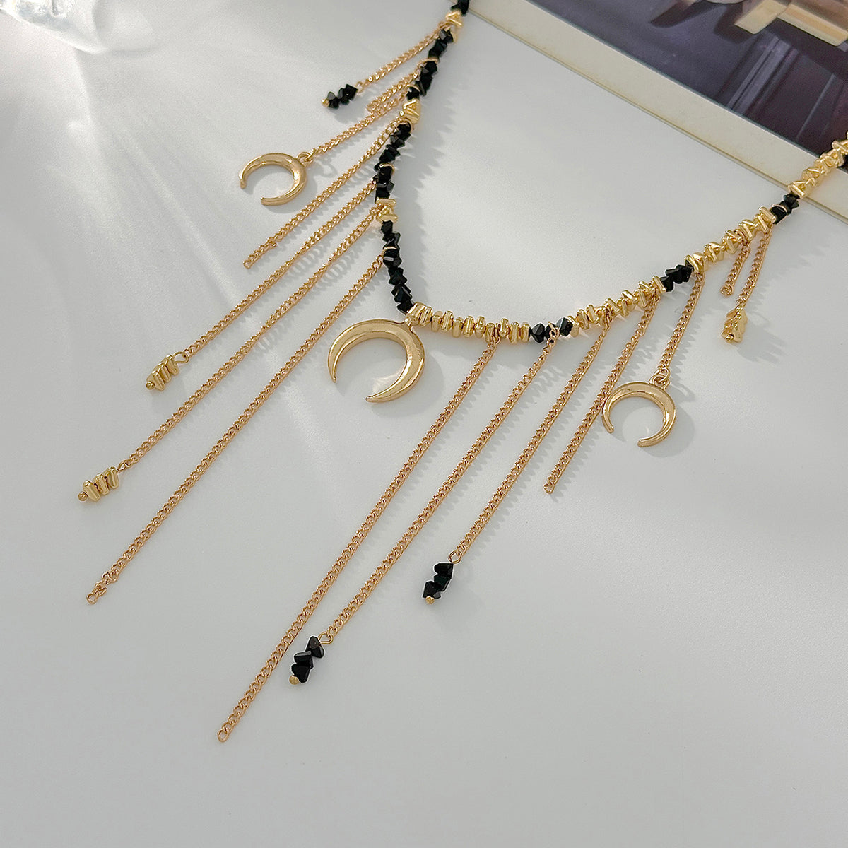 Black Acrylic and Goldtone Moon Pendant Tassel Necklace, dainty minimalist design, detail close-up