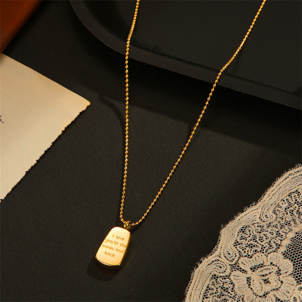 Beautiful 18K gold-plated dog tag necklace showcasing the touching phrase, "Love You To The Moon & Back."