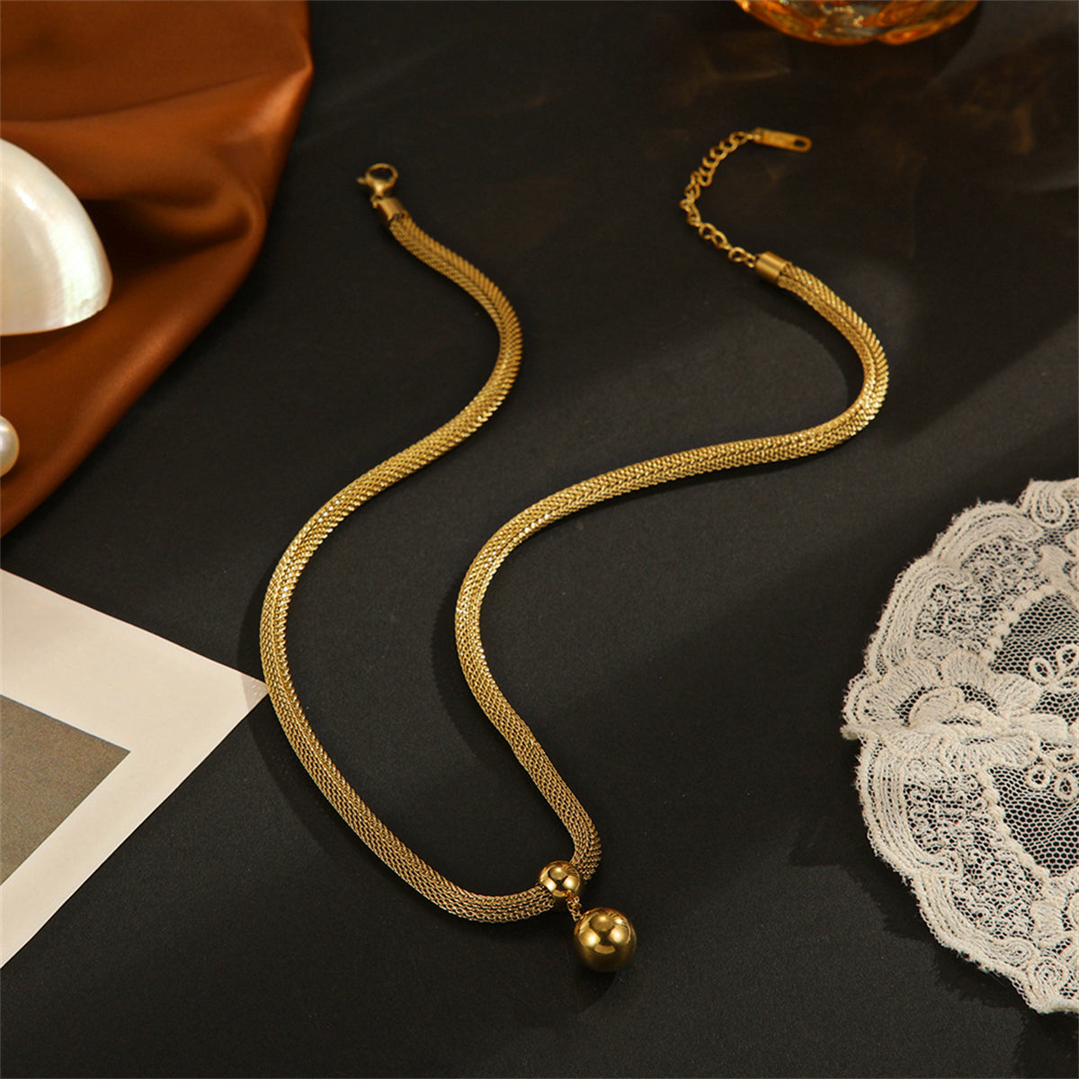 Beautiful 18K gold-plated ball necklace with a mesh chain, showcasing a striking gold ball pendant for a touch of elegance.