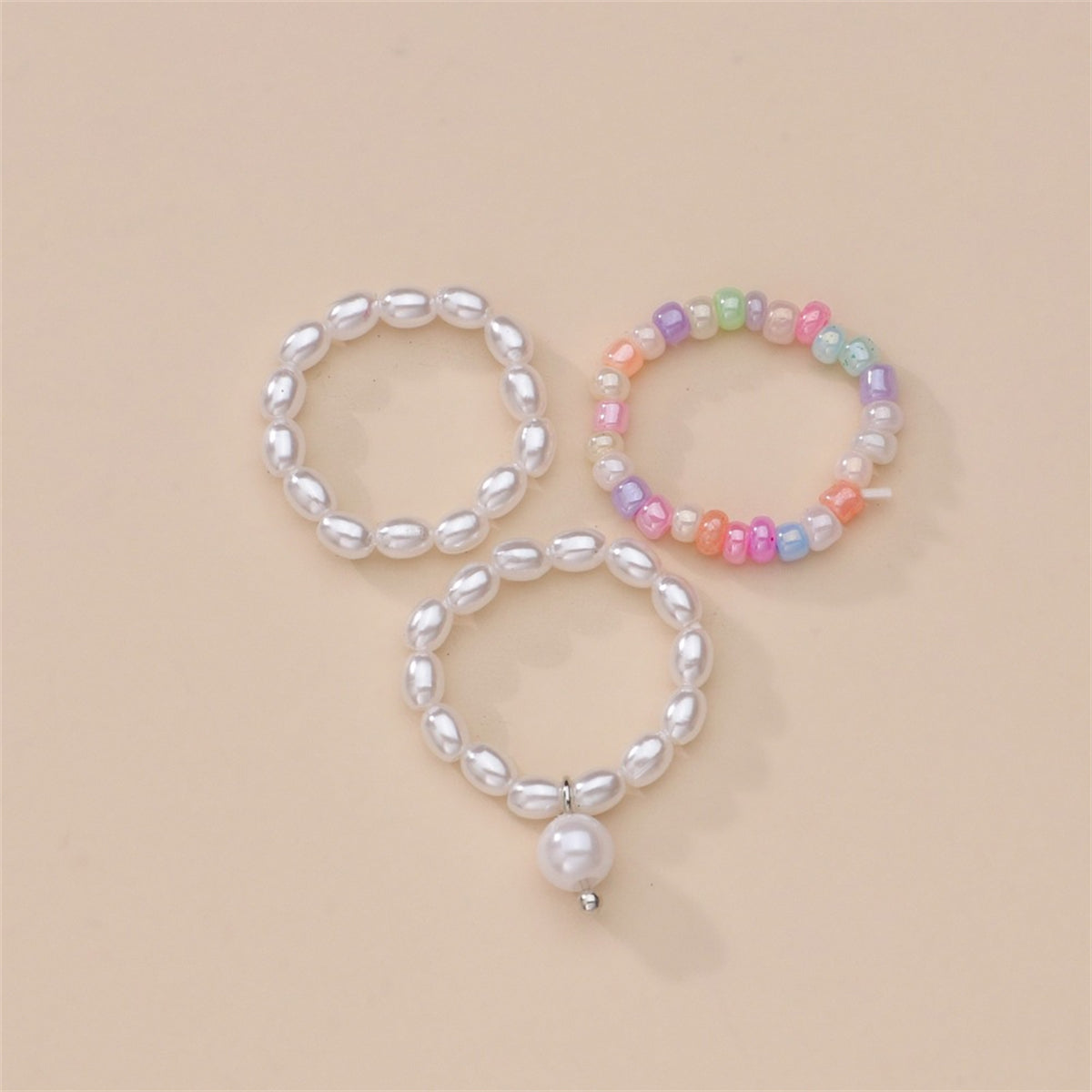A set of three vibrant rings adorned with pearls and a charming pearl accent, designed as a stretch ring set.