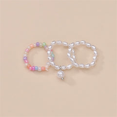 Three distinct rings showcasing pearls and a pearl charm, crafted as a stylish beaded stretch ring set.