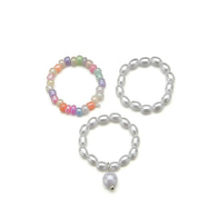 A trio of colorful rings with pearls and a pearl charm, beautifully arranged as a pearl and howlite beaded stretch ring set.