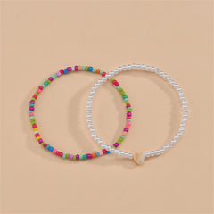  Two vibrant anklets with colorful beads and a heart charm, designed as a red multicolor howlite anklet set.