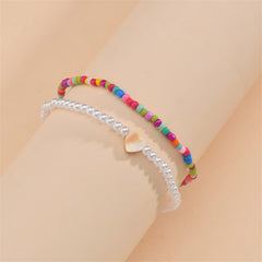 Colorful beaded anklets with a heart charm, part of a red multicolor howlite stretch anklet set.