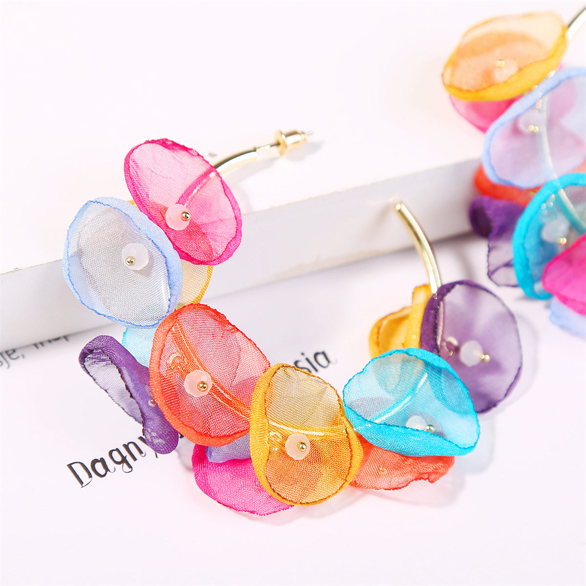 A set of pastel petal hoop earrings in vibrant colors, made from polyester and acrylic with 18K gold plating.