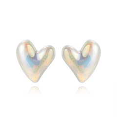 Elegant white heart-shaped stud earrings made of pearl and silver plating, showcasing a tilted design for added flair.