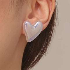A pair of pearl and silver-plated tilted heart stud earrings in white, elegantly designed for a stylish look.