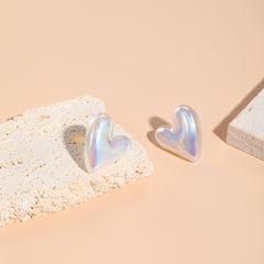 A stylish pair of tilted heart stud earrings in white, crafted from pearl and silver plating for a sophisticated touch.