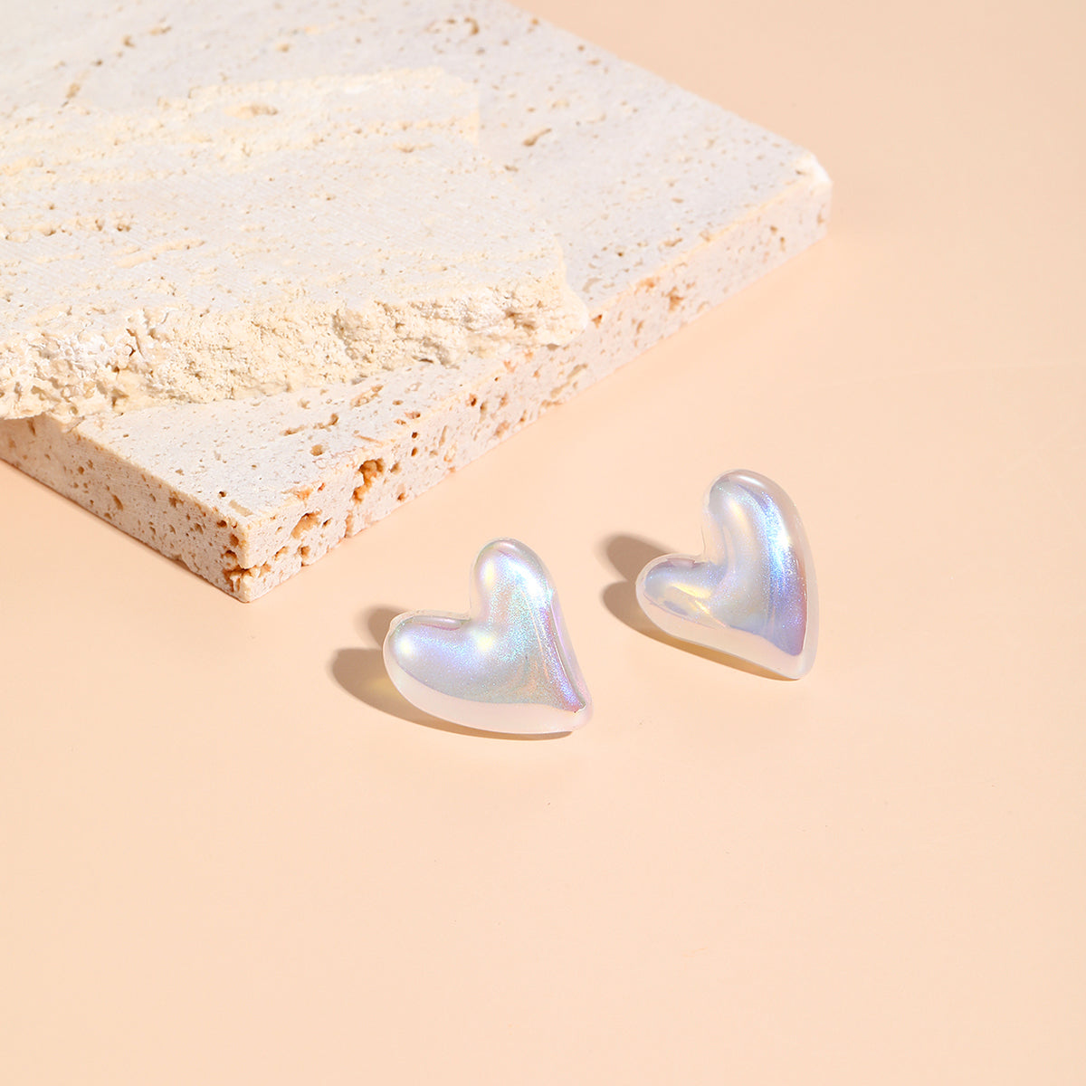 White heart-shaped earrings with a tilted design, made from pearl and silver plating, perfect for any elegant outfit.