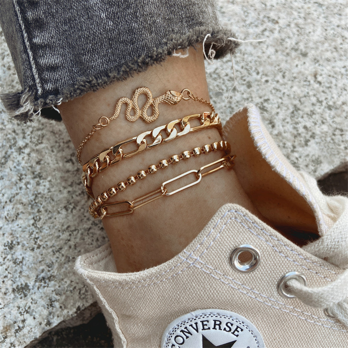 Elegant gold chain anklets featuring a stylish snake charm, perfect for adding a touch of luxury to any outfit.