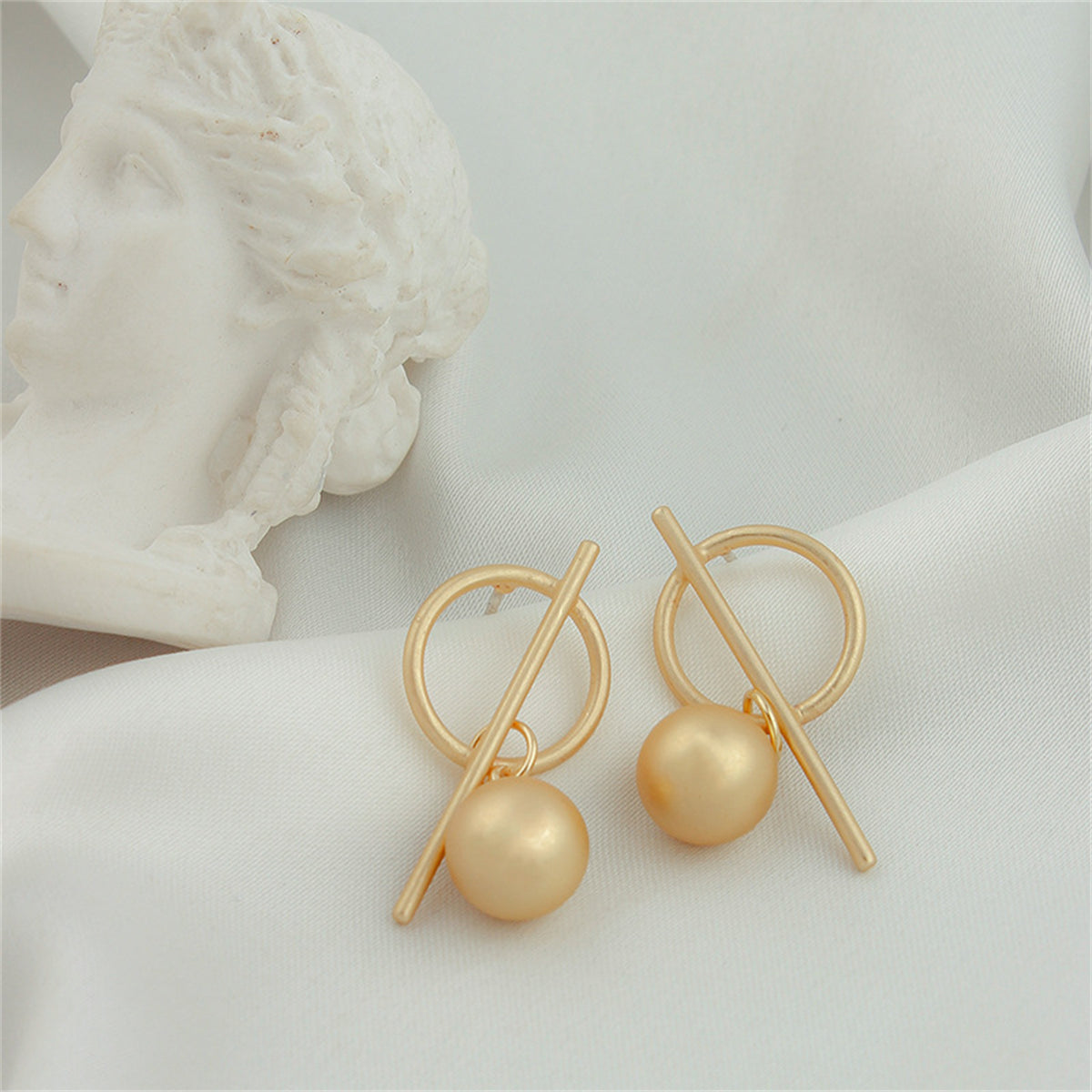Eye-catching 18K gold-plated ball drop earrings with a modern circle and cross, perfect for a fashionable statement.