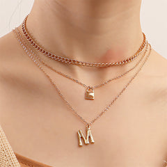 Elegant 18K gold-plated necklace featuring a layered 'M' lock pendant and a delicate key charm, perfect for any occasion.