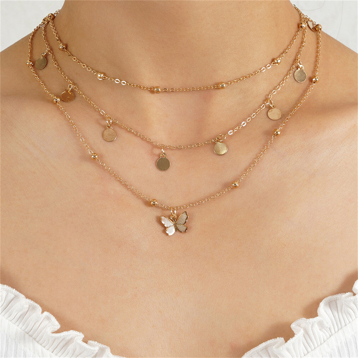 Elegant 18K gold-plated butterfly necklace featuring three layers of shimmering gold beads for a stunning look.