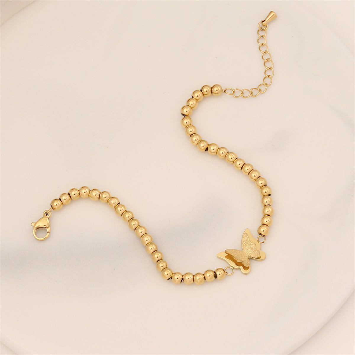 Stunning 18K gold-plated butterfly charm bracelet featuring delicate beads, ideal for a stylish and sophisticated look.