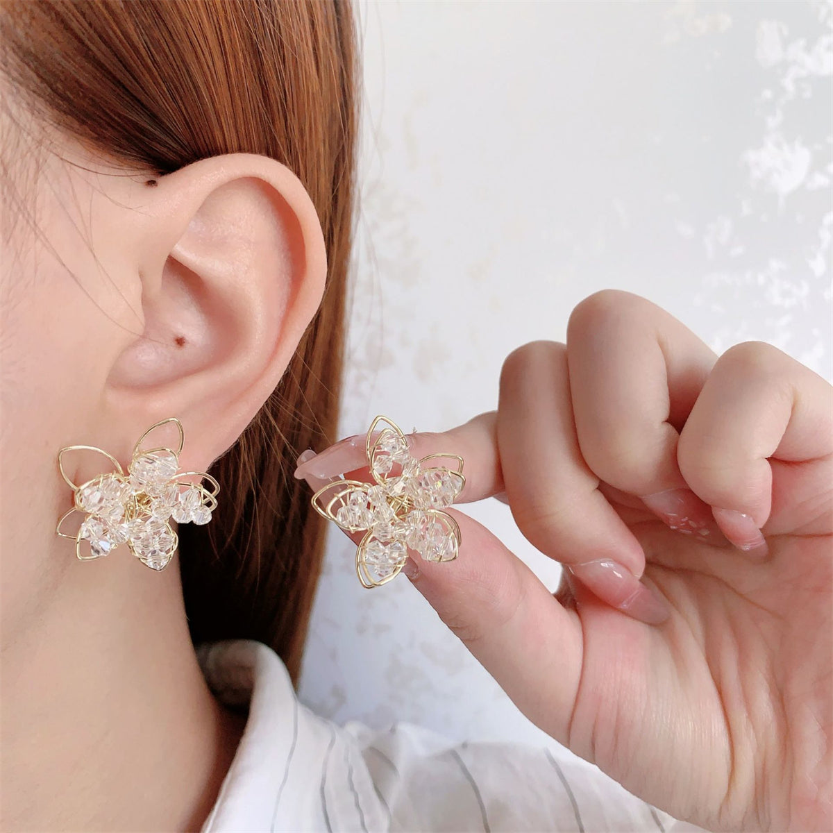 Chic gold-plated floral stud earrings with sparkling clear arylic, a stylish choice for any occasion or outfit enhancement.