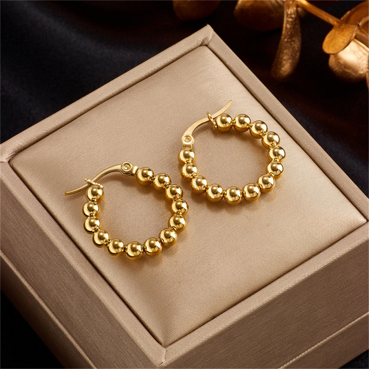 Chic pair of gold ball hoop earrings, made with 18K gold plating, ideal for a sophisticated and fashionable statement.