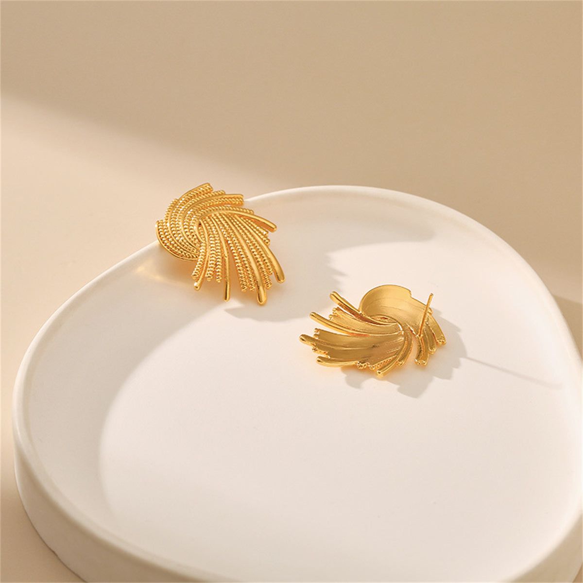 Eye-catching 18K gold-plated twisted earrings, combining elegance and modern design for a standout accessory choice.