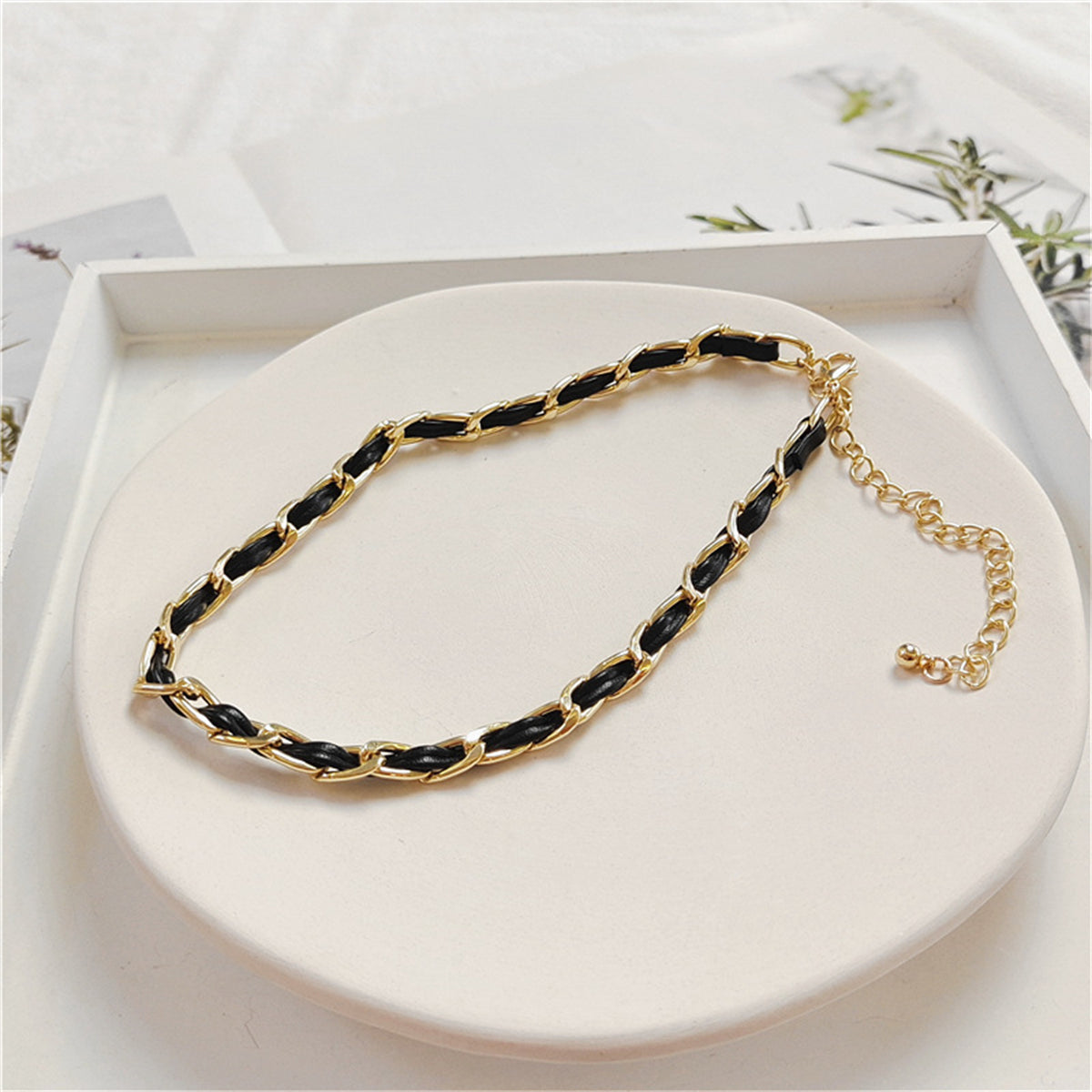 Sophisticated black and gold chain choker, designed with 18K gold-plated elements and a minimalist polystyrene cable chain.