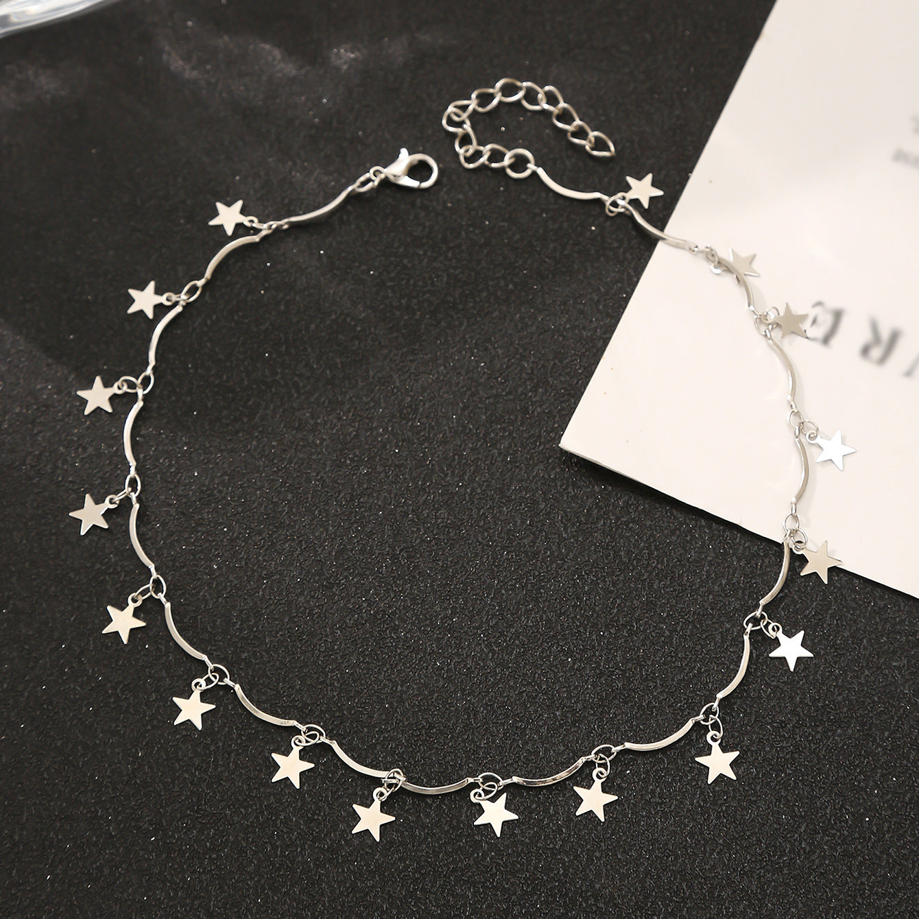 A silver-plated star choker necklace with small stars linked together, adding a whimsical touch to any outfit.