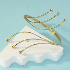 Stunning 18K gold-plated arm cuff adorned with four chic beads, perfect for any fashionable outfit.