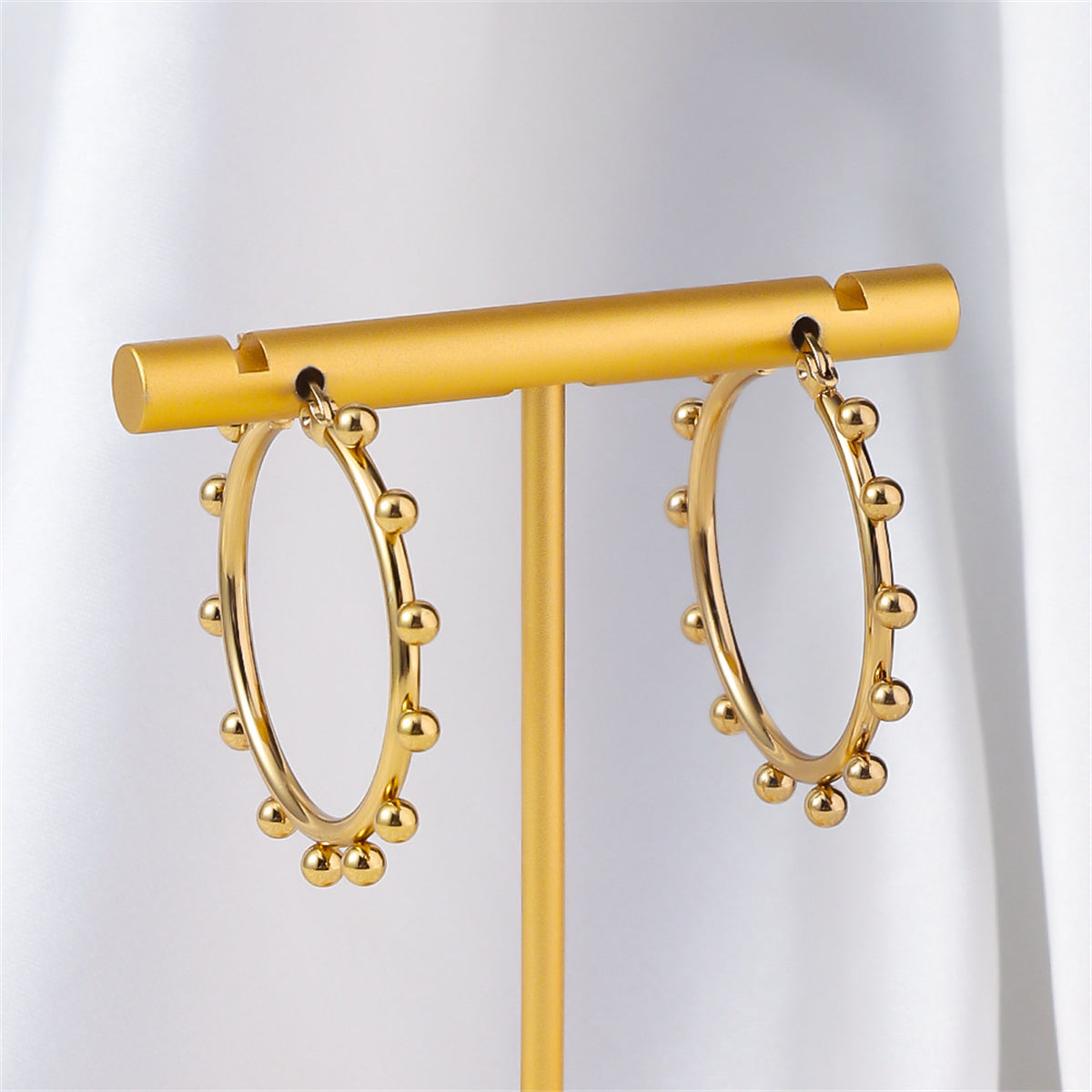 Chic 18K gold-plated hoop earrings embellished with small balls, ideal for elevating your everyday jewelry collection.