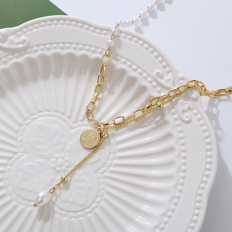 Beautiful gold chain necklace showcasing a pearl and a gold coin charm, ideal for elevating any outfit with elegance.