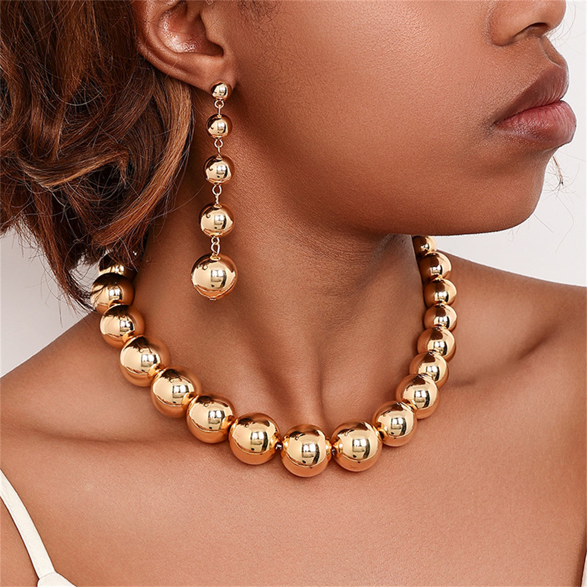 Stunning 18K gold-plated necklace with a golden ball pendant, elegantly hanging from a sleek gold chain.