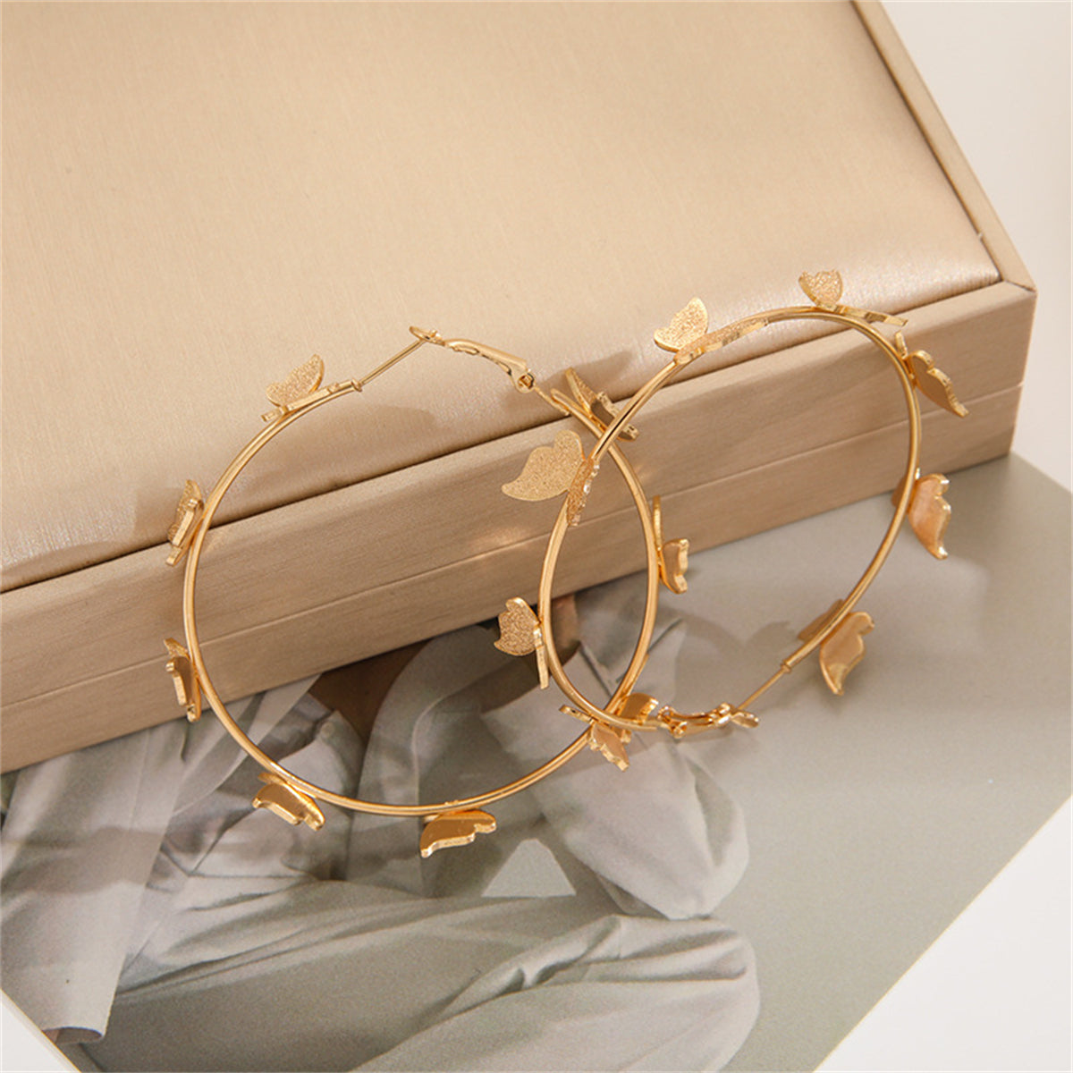 Dazzling 18K gold-plated butterfly hoop earrings, designed to add a playful yet sophisticated flair to your ensemble.