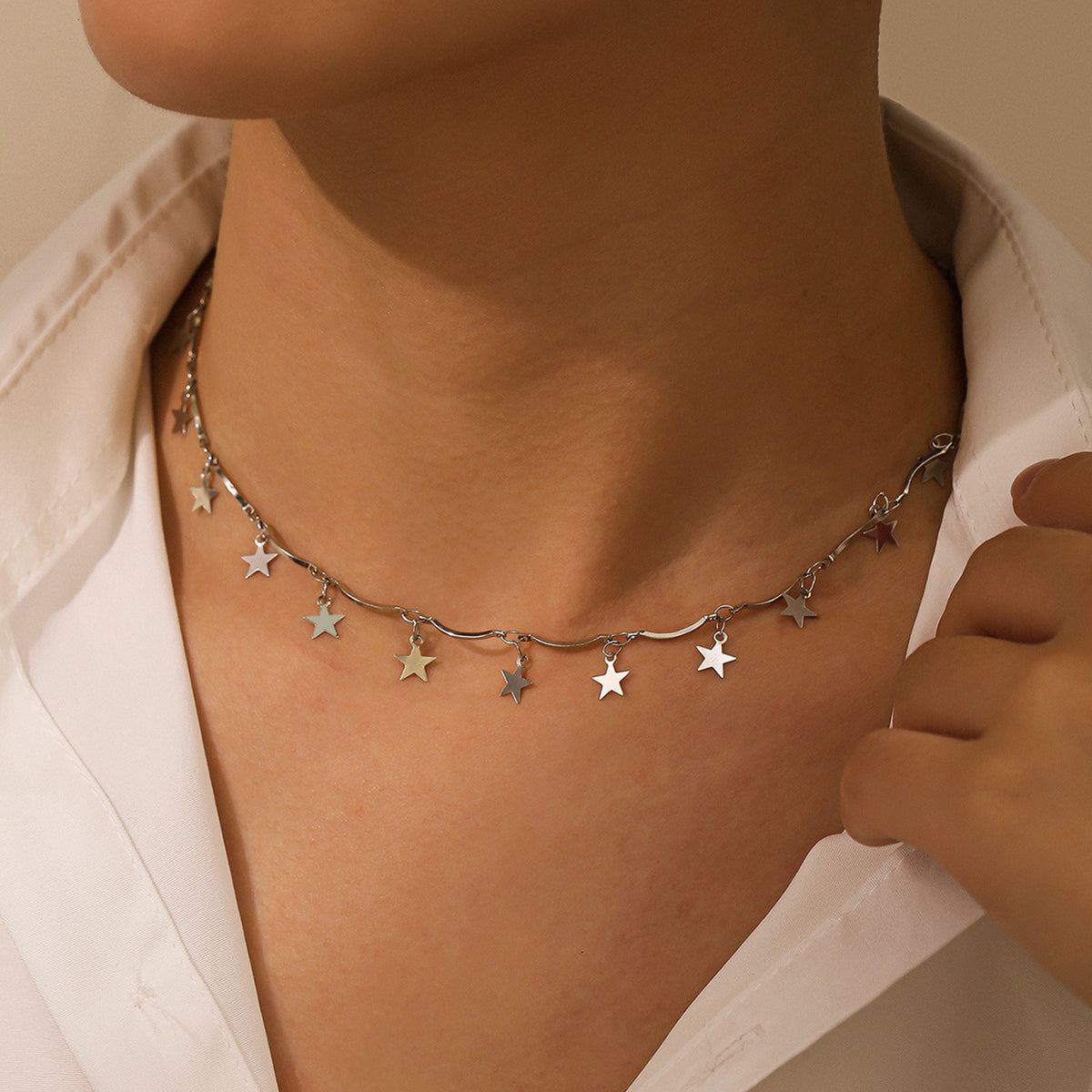 Silver-plated choker necklace featuring small stars linked on a delicate chain, perfect for a celestial-inspired look.
