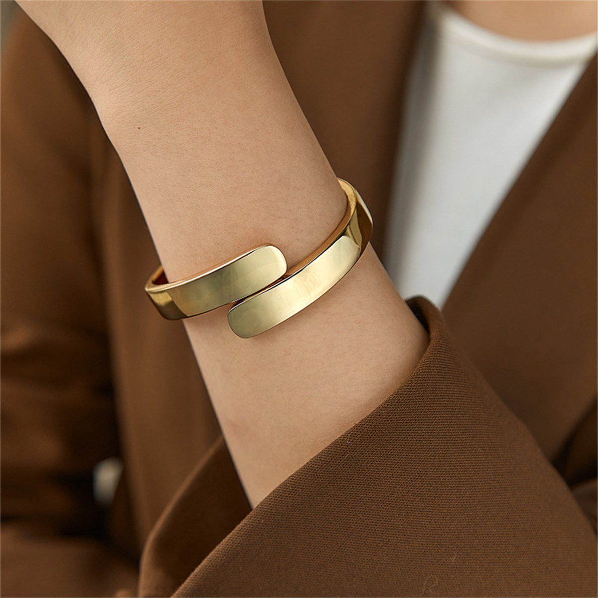 Elegant 18K gold-plated bangle bracelet featuring a stylish bypass hinge and two graceful curved edges.