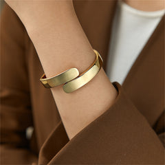Elegant 18K gold-plated bangle bracelet featuring a stylish bypass hinge and two graceful curved edges.