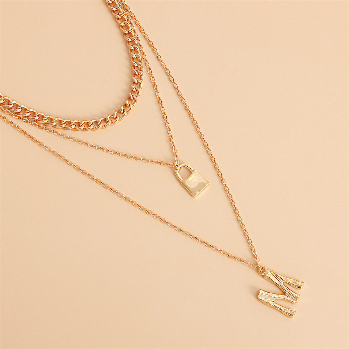 Exquisite 18K gold-plated necklace featuring a layered 'M' lock pendant and key, perfect for making a bold fashion statement.
