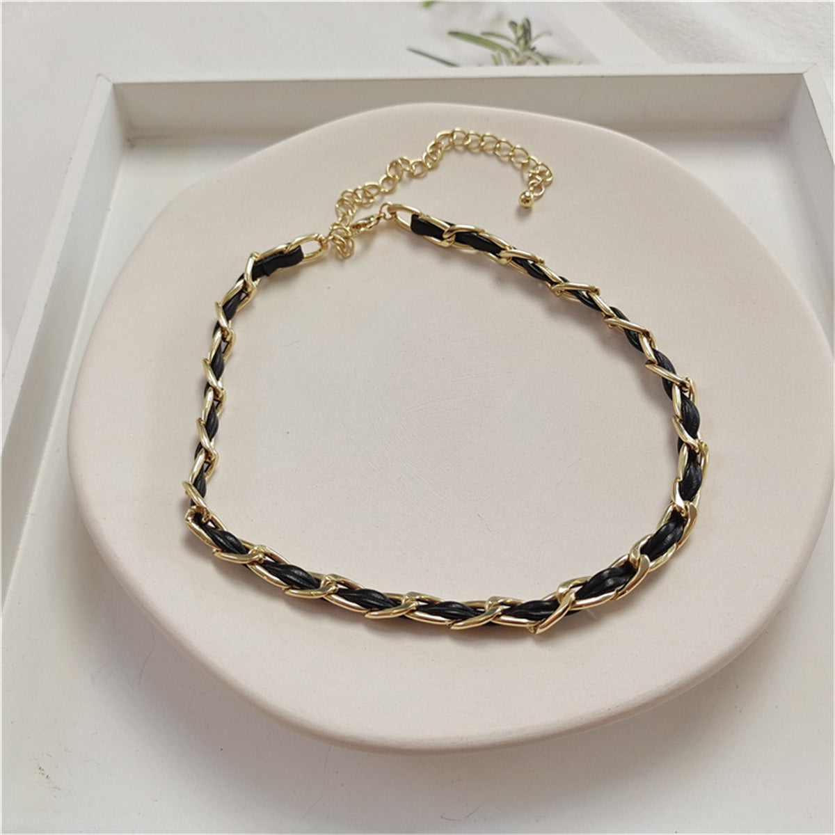 Timeless black and gold chain choker, featuring a refined 18K gold-plated design and a contemporary polystyrene cable chain.