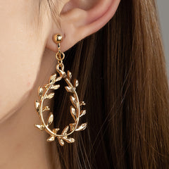 Elegant 18K gold-plated earrings featuring a botanical wreath design with delicate leaf accents. Perfect for any occasion.