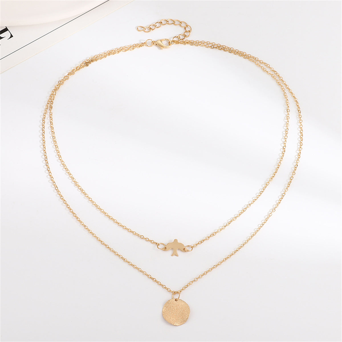 Two exquisite gold-plated necklaces featuring a bird charm, a stylish addition to any jewelry ensemble for a chic look.