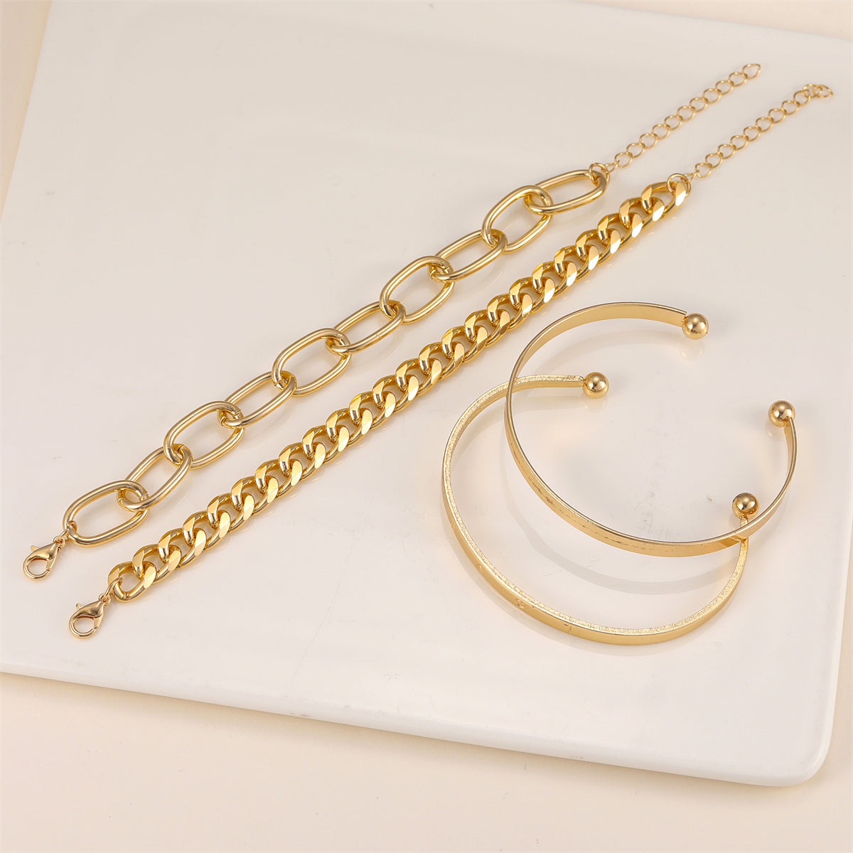 Chic 18K gold-plated cuff set with three gold chain bracelets, each embellished with a charming heart for a trendy touch.
