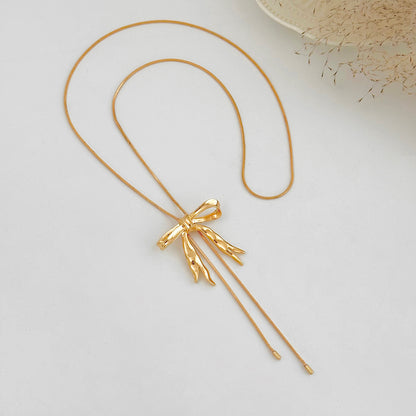 Goldtone Bow Tassel Pendant Necklace, vintage-inspired design, detail close-up