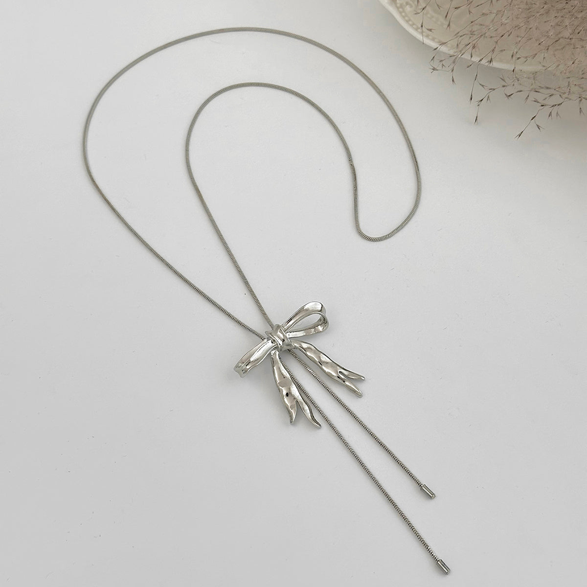 Silvertone Bow Tassel Pendant Necklace, vintage-inspired design, detail close-up