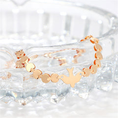 Chic 18K gold-plated bracelet with a whimsical bird charm and a heart charm, a lovely addition to your jewelry collection.