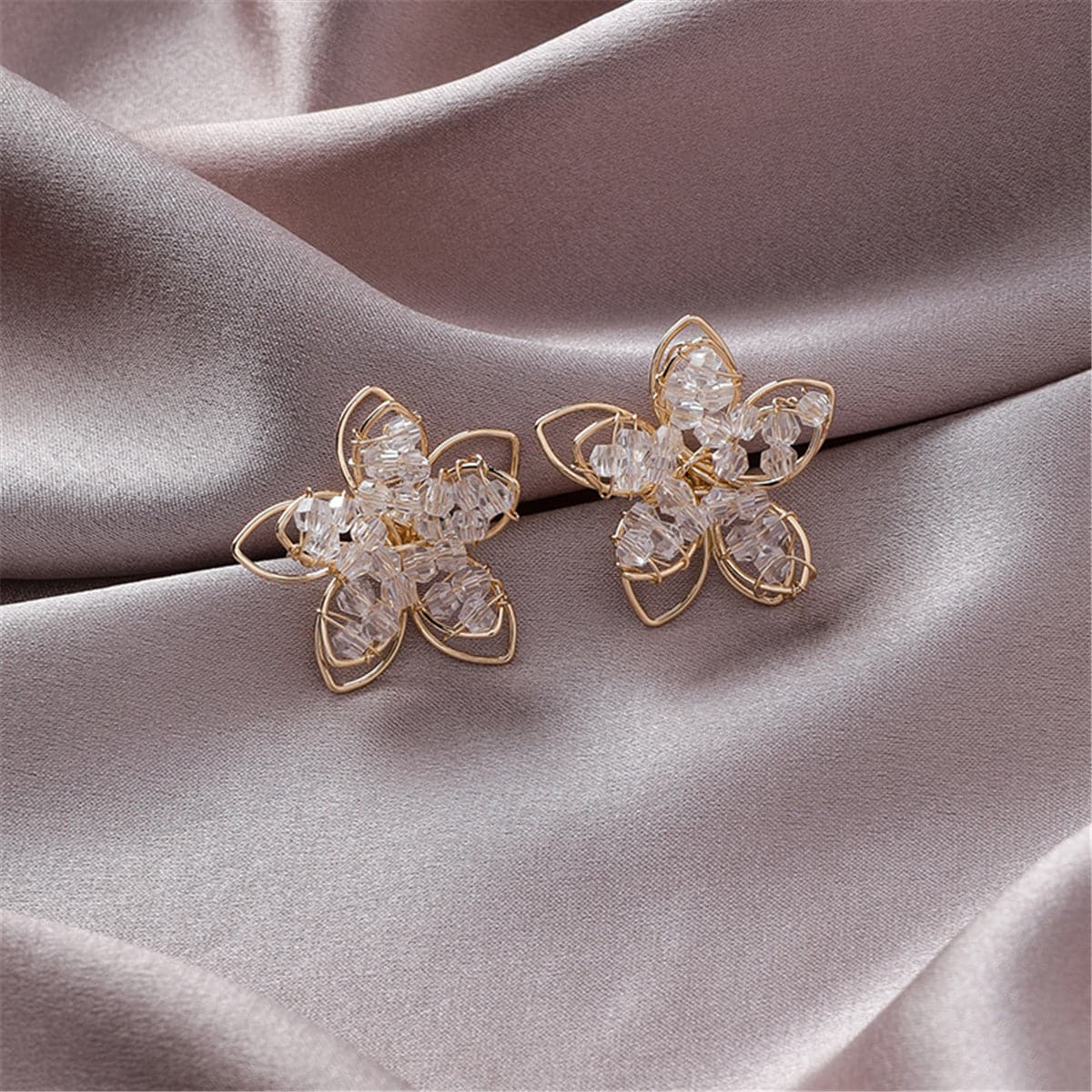 Dazzling flower-shaped earrings in gold-plated frame, set with clear acrylic, perfect for adding glamour to your jewelry collection.