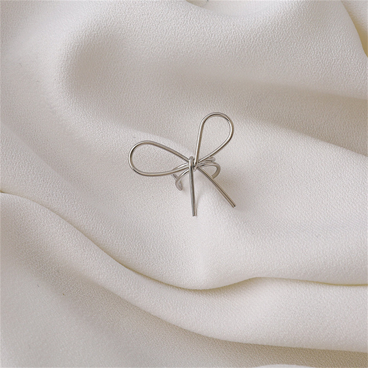 Silver-Plated Bow Ear Cuff, silver stud earrings for women, dainty minimalist design, front view