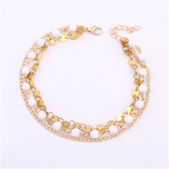 Chic 18K gold-plated anklet showcasing a gold chain interspersed with white beads, ideal for stylish accessorizing.