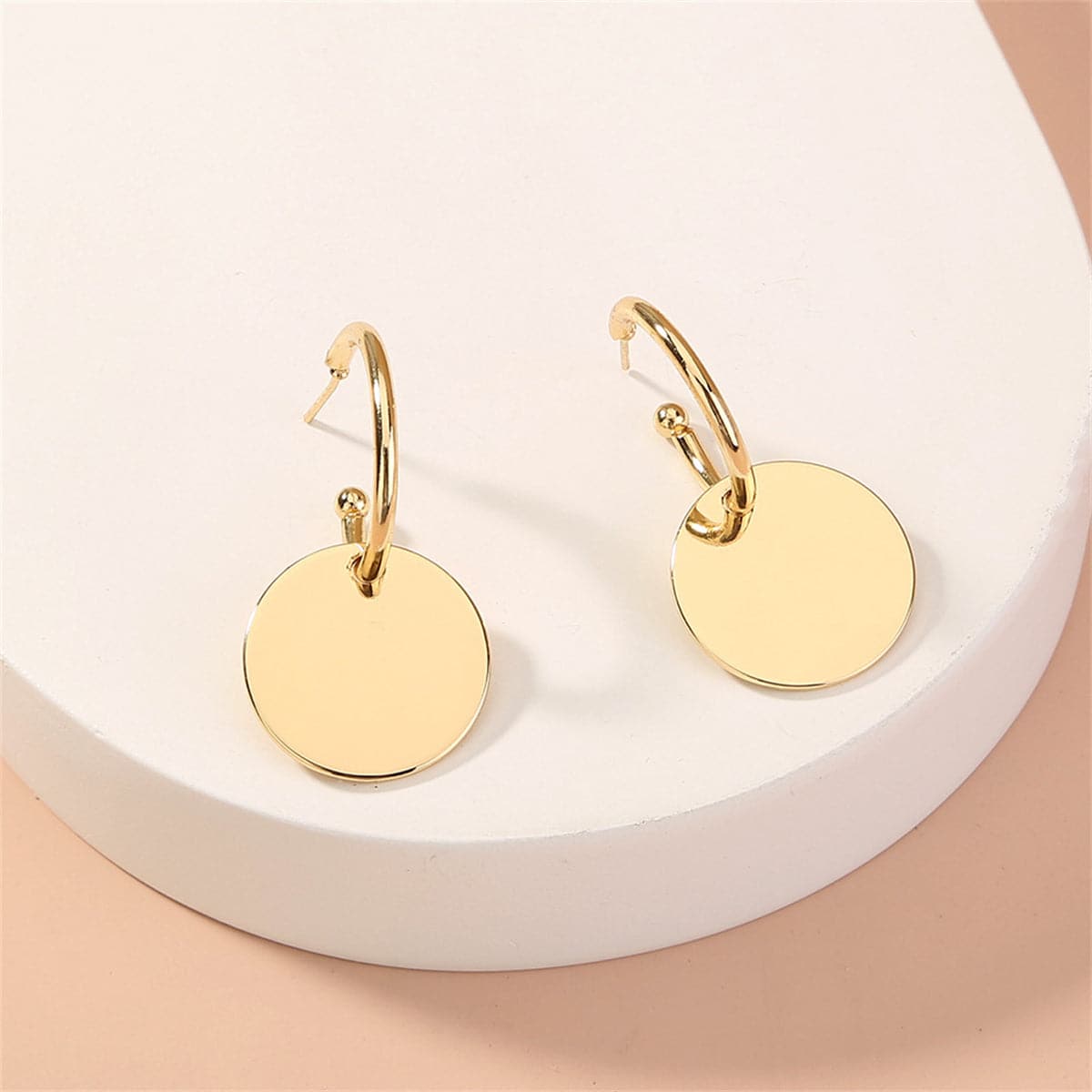 Fashionable 18K gold-plated huggie earrings featuring a unique circle design paired with a small disc for a sophisticated touch.