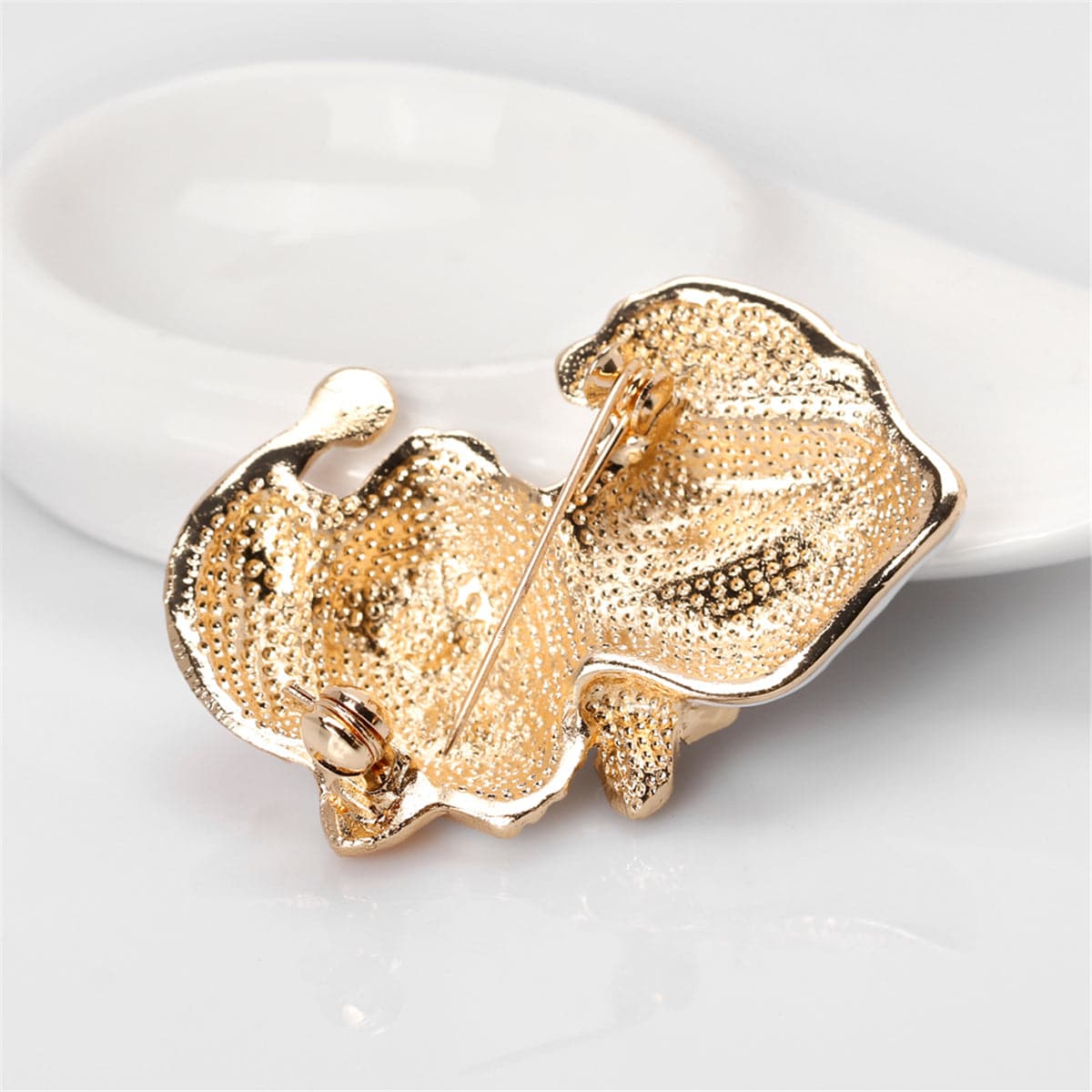 A sophisticated black cat brooch wearing a Santa hat, featuring 18K gold plating and radiant cubic zirconia accents.