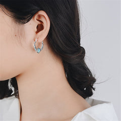 Turquoise stone hoop earrings with silver plating, featuring decorative feather elements for a chic and trendy look.