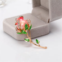 Elegant pink rose brooch with vibrant green leaves, beautifully designed in 18K gold plating and cubic zirconia accents.