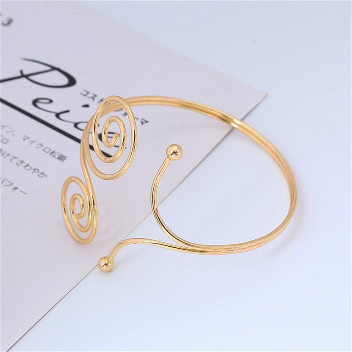 Stylish gold-plated spiral arm cuff showcasing a double swirl design, ideal for elevating your jewelry collection.