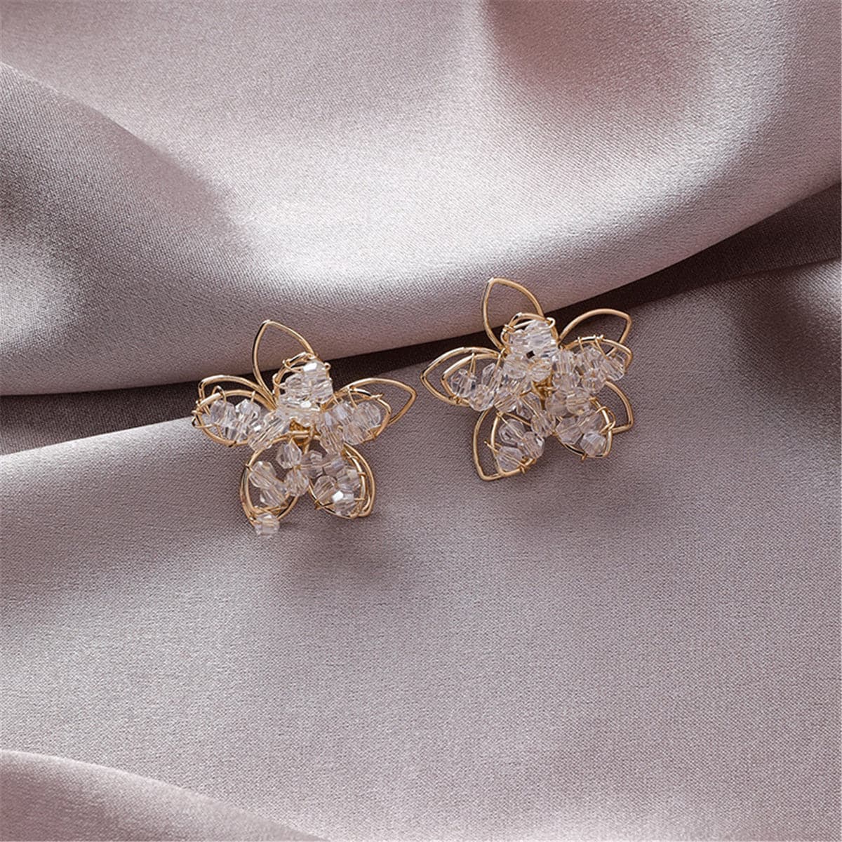 Elegant 18K gold-plated floral stud earrings adorned with clear arylic, perfect for adding a touch of sparkle to any outfit.