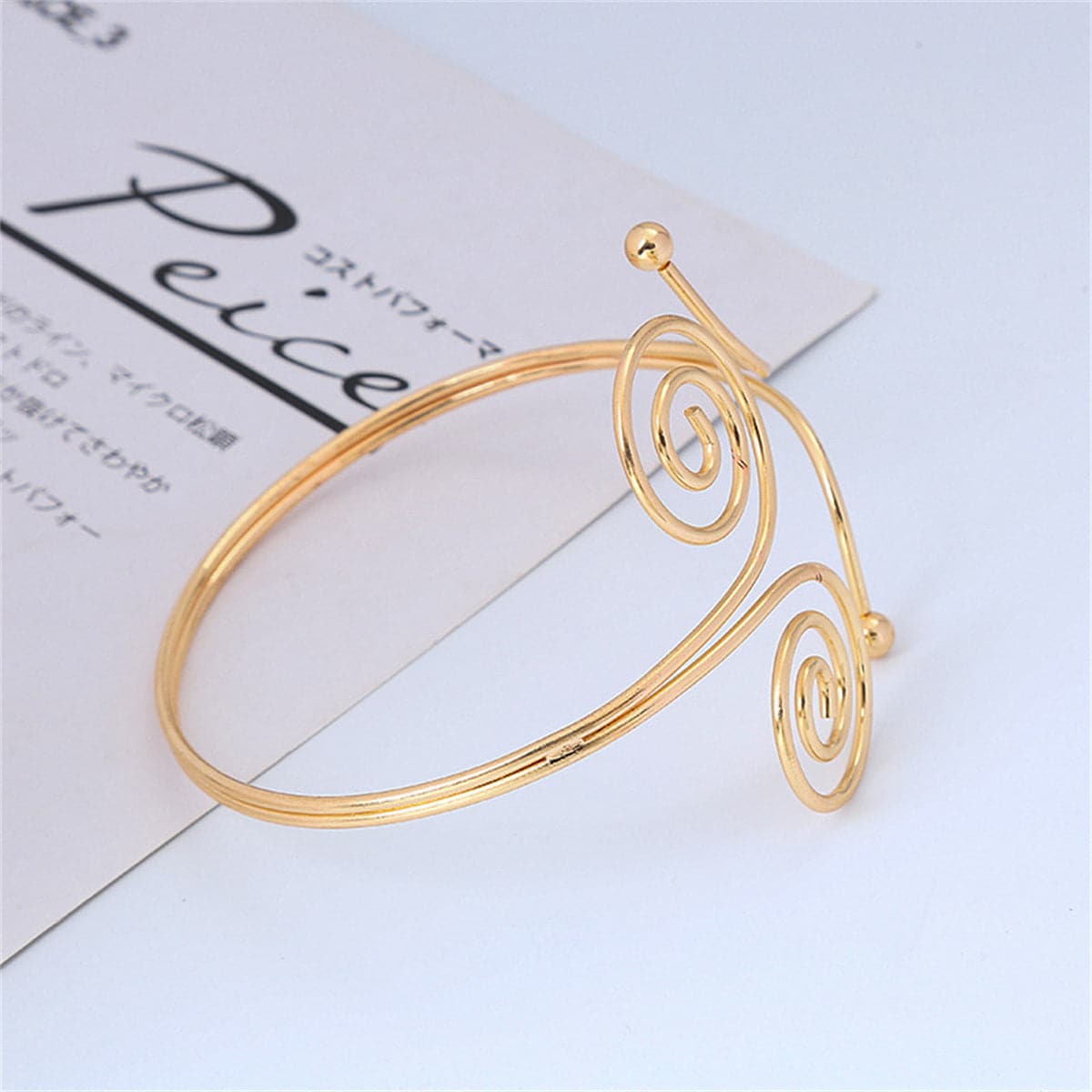 Beautiful 18K gold-plated arm cuff with a captivating spiral design, perfect for a sophisticated look. 